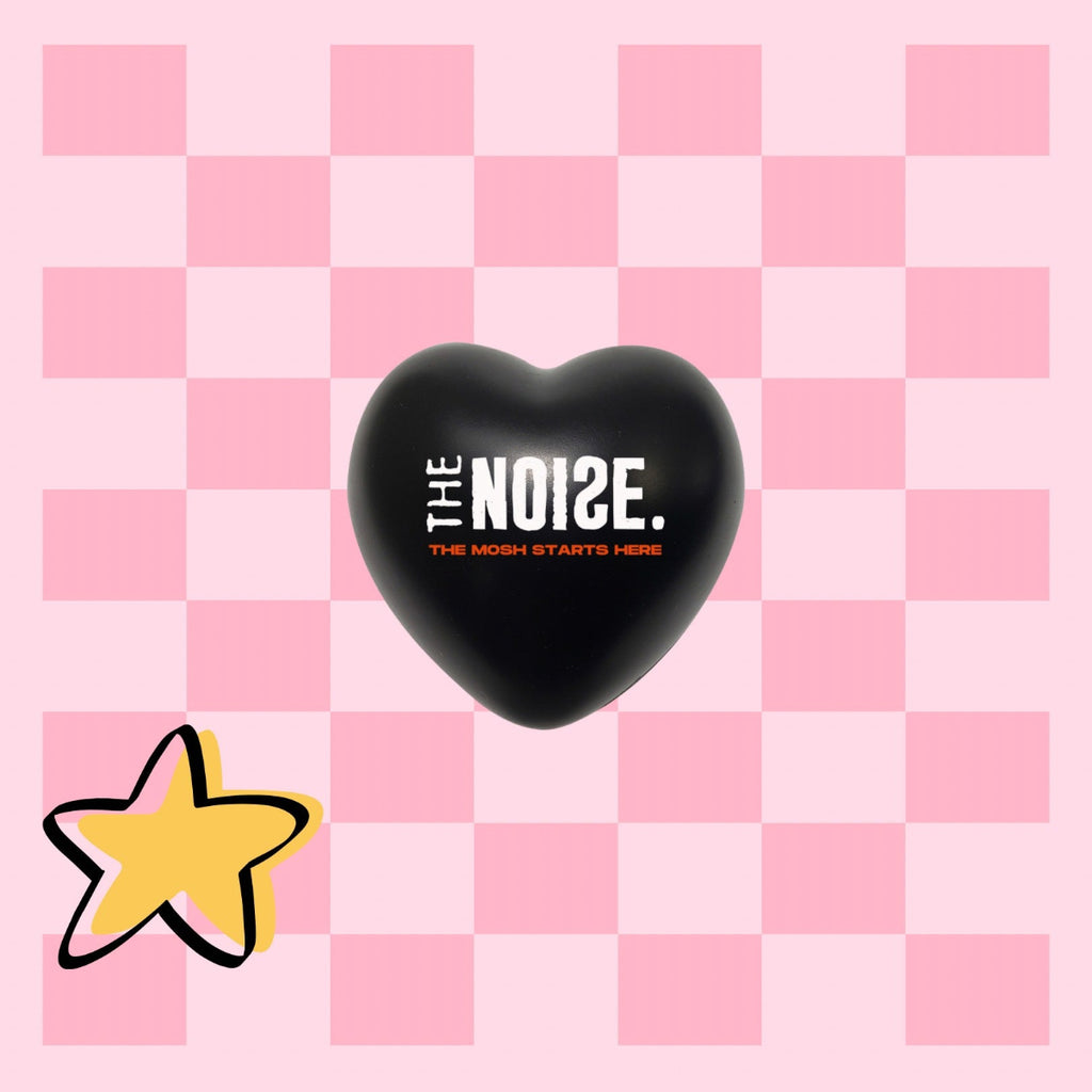 Black heart-shaped object with 'The Noise' text on a pink checkered background